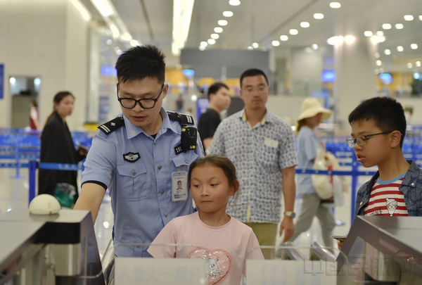 民警帮助小旅客自助通关-通讯员魏文亨摄.jpg 民警帮助小旅客自助通关-通讯员魏文亨摄.jpg