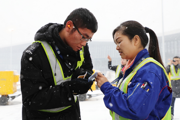 nEO_IMG_图：飞机监护员雪中查验登机人员证件 赵振龙摄.jpg