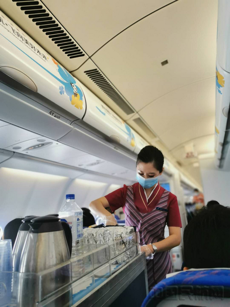 nEO_IMG_乘务员戴着一次性手套为旅客提供餐食服务.jpg