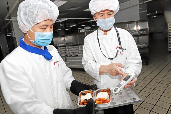 深航配餐工作人员正在检测烤制双拼饭的温度及时间监测.jpg
