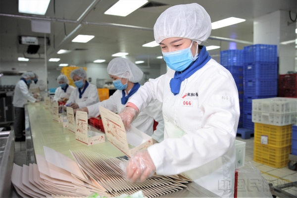 深航配餐人员在摆盘车间分装机上餐食.jpg