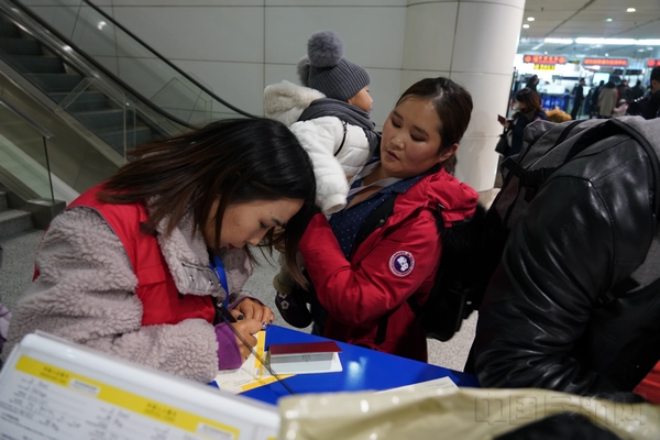 国航内蒙古分公司招募的志愿者帮助孩子和家属填写入境卡。摄影孙欣.jpg 国航内蒙古分公司招募的志愿者帮助孩子和家属填写入境卡。摄影孙欣.jpg