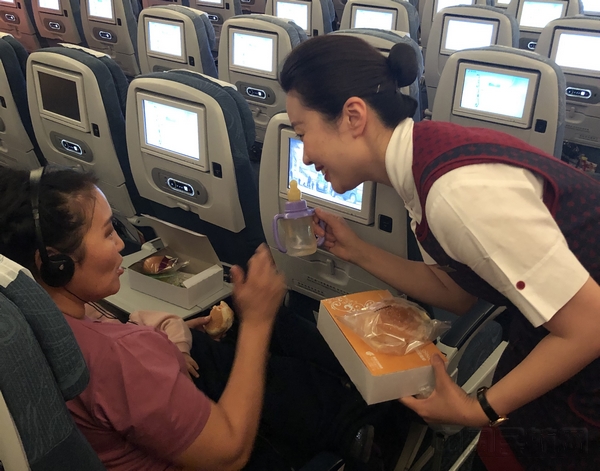 国航乘务员为婴儿和家属准备温水及餐食。摄影朱晋.jpg 国航乘务员为婴儿和家属准备温水及餐食。摄影朱晋.jpg