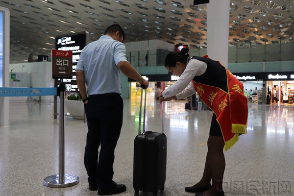 深航行李管控岗工作人员正在为旅客测量行李尺寸.jpg 深航行李管控岗工作人员正在为旅客测量行李尺寸.jpg