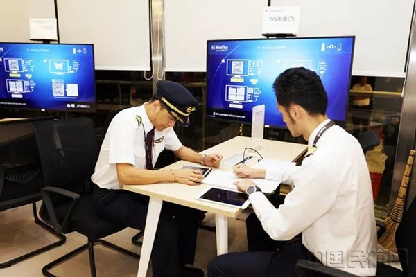 在签派现场，飞行员通过纸质资料沟通询问_图：杨茜.jpg
