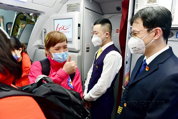 图  北部湾航空总飞行师程春鑫（右一）在机舱门口迎接广西援鄂“白衣天使”登机_副本.jpg