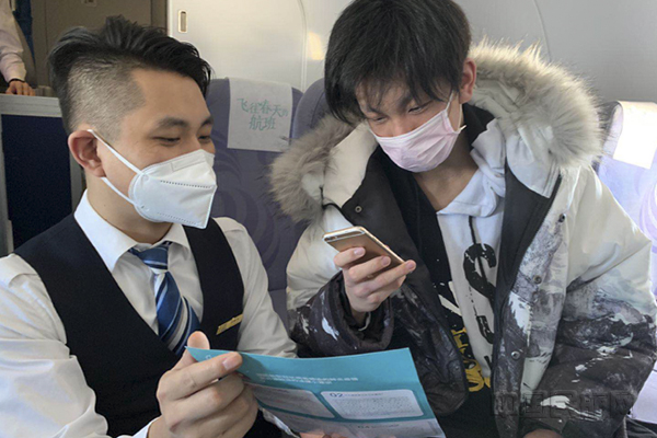 华夏航空乘务员引导旅客参与线上扫码答题 .jpg 华夏航空乘务员引导旅客参与线上扫码答题 .jpg