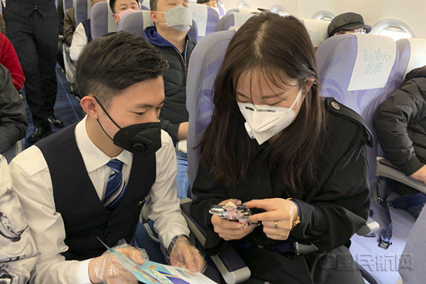 华夏航空客舱乘务员引导旅客参与线上扫码答题.jpg 华夏航空客舱乘务员引导旅客参与线上扫码答题.jpg