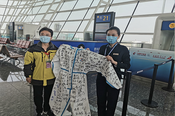 医疗队员在登机口给东航员工送上写满签名的防护服-东航供图1.jpg