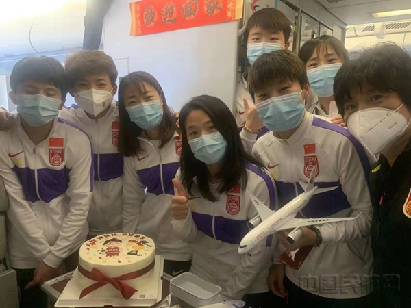 东航乘务组为水庆霞指导（右一）和女足姑娘准备欢迎蛋糕和祝福书法-东航供图_副本.jpg