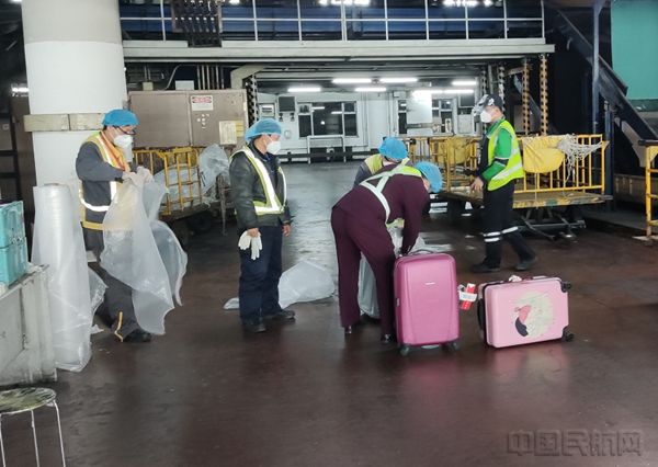 附图3:海南航空为“博鳌亚洲论坛”航班宾客出港托运行李进行气泡膜包裹(黄雷 摄)3