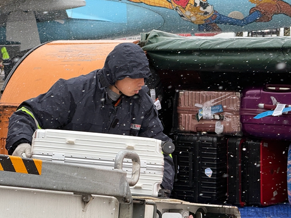 虹桥机场机坪内,东航地服人员正在风雪中搬运行李-东航供图07